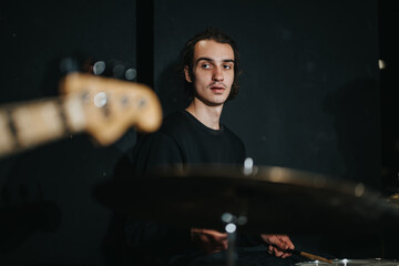 Energetic drummer playing in a studio, focusing on rhythm and musical performance in an artistic environment. Capturing the essence of creativity and passion for music.