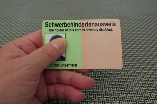 Eine Frau h&auml;lt einen Schwerbehindertenausweis in der Hand 