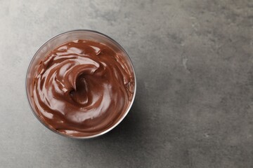 Tasty chocolate pudding on grey table, top view. Space for text