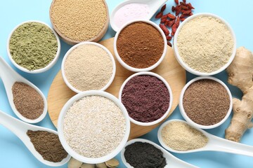 Different superfoods on light blue background, flat lay