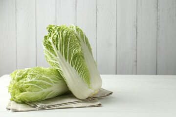 Fresh Chinese cabbages on white wooden table, space for text
