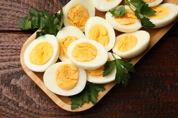 Boiled eggs and parsley on wooden table, top view