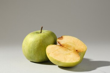 Damaged green apples on light grey background