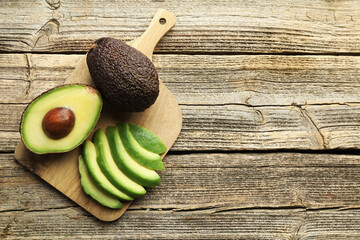 Tasty ripe green avocados on wooden table, top view. Space for text © New Africa
