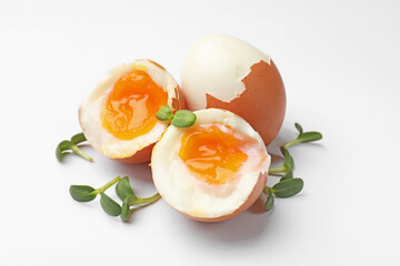 Soft boiled eggs with microgreens on white background