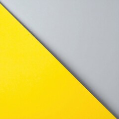 A vibrant yellow triangle stands out prominently against a smooth, muted grey background, creating a striking contrast that draws the eye.