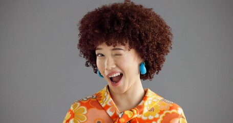 Woman, wink and portrait in studio with retro style, smile and joke with secret deal on grey...