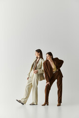 Stylish twin sisters showcasing their unique fashion sense in a modern studio setting