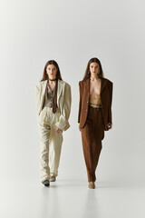 Stylish twin sisters confidently strut down a minimalist runway showcasing modern fashion