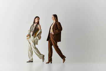 Stylish twin sisters showcase unique fashion in a contemporary art space with elegance and flair