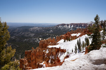 View of red rocks in Bryce Canyon partially covered with snow. Bryce Canyon in May. Utah, USA.	