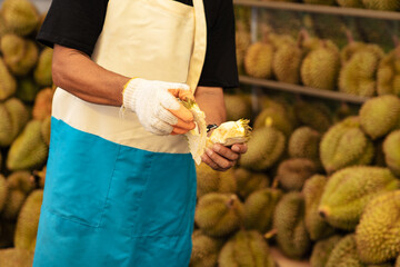 Man Peeling Fresh Durian at Tropical Fruit Market in Thailand