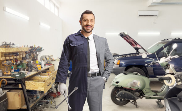 Businessman wearing auto mechanic uniform and holding a wrench