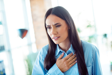 Young woman in formal wear showing emotion indoors in a naturally lit office environment