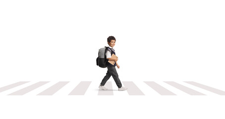 Asian schoolboy in a uniform walking at a zebra crossing and holding a book