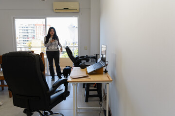 Young woman at home checking her phone while taking a break from her remote work