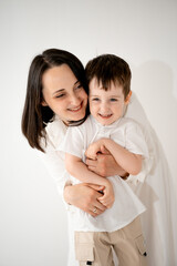 a mother and child hug and play, having fun on a white isolated background, a mother and a small child, a mother and son.