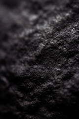 Extreme close up of painted in black handmade paper clay with a structure and rough texture. Paper recycling. Selective focus, shallow depth of field.