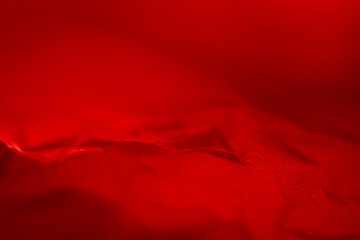 Extreme close up of red empty plastic bag background. The plastic surface is wrinkly and tattered...