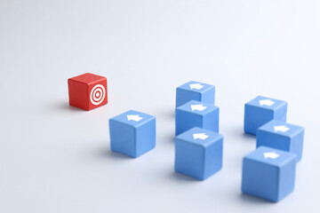 Targeting. Light blue cubes with arrows pointing at red one with bullseye on white background