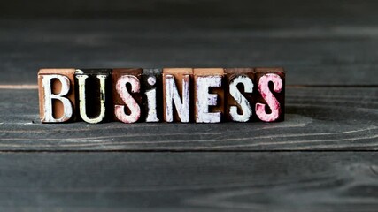 BUSINESS. Alphabet blocks on a wooden texture background. 4K video