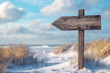 Naklejka premium Rustic wooden signpost on a snowy beach path