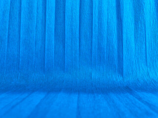 Abstract background made of blue crepe paper with vertical folds and texture