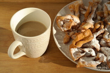 Crispy homemade cookies on a plate and a cup of coffee.