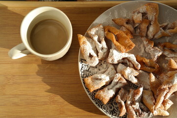 Crispy homemade cookies on a plate and a cup of coffee.