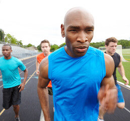 Fitness, running and men at outdoor track with race, marathon or relay for charity event. Sports,...
