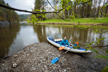 An Adventurous Kayaker Embarks on a Trip Along a Serene Riverbank, Immersed in the Beauty of Nature and Surrounded by Lush Greenery, Inspiring a Deep Appreciation for the Great Outdoors