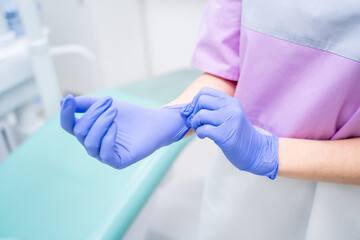 A Medical Professional Donning Protective Gloves in a Clinic Setting for Patient Care