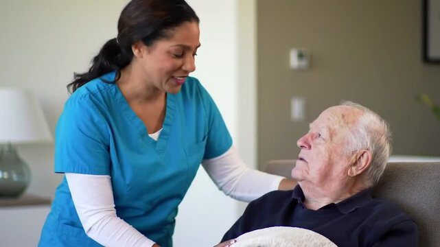 Friendly Caretaker Draping Blanket Over Elderly Man Seated in Living Room in a Warm Eye Level Shot Featuring Compassionate Interaction