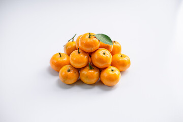Eid hampers containing dry cakes in jars such as nastar, roasted peanuts without skin, oranges, and sweets on a white background with typical Eid ornaments