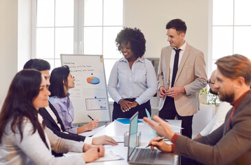 Team of business people gathers in the office for a work meeting or conference. The event focuses on teamwork, collaboration, successful business strategies and colleague interactions.