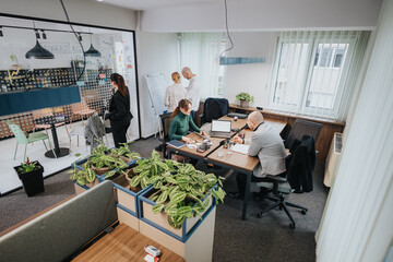 Team members in a contemporary office working on projects, discussing ideas, and analyzing data, emphasizing teamwork and productivity.