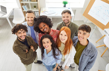 Happy group of multinational professional business people standing together in an office, smiling...
