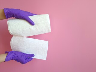 Housekeeping and hygiene concept. Hand in purple rubber glove holding paper towel roll