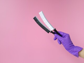 Housekeeping and hygiene concept. Hand in purple rubber glove holding two cleaning brushes