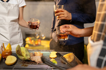 Friends gather indoors at a colorful bar, raising glasses in joyful celebration, enjoying drinks, laughter, and lively conversation in a vibrant, social atmosphere.