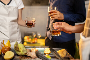 Friends gather indoors at a colorful bar, raising glasses in joyful celebration, enjoying drinks, laughter, and lively conversation in a vibrant, social atmosphere.