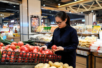 Woman Shopping for Tomatoes in Supermarket