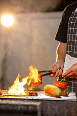 Juicy, tender steak sizzles over open flames on a rustic barbecue grill, with herbs and smoke enhancing the rich aroma of outdoor cooking.
