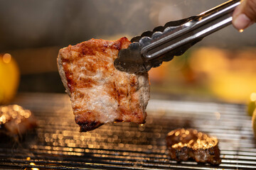 Juicy, tender steak sizzles over open flames on a rustic barbecue grill, with herbs and smoke enhancing the rich aroma of outdoor cooking.
