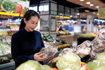 Asian Woman Shopping for Vegetables in Supermarket