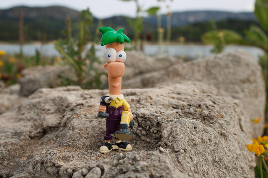 Mu&ntilde;eco de Ferb Fletcher de pl&aacute;stico sobre una roca con sus herramientas visitando el pantano, Beniarres el 15 de mayo de 2025, Espa&ntilde;a