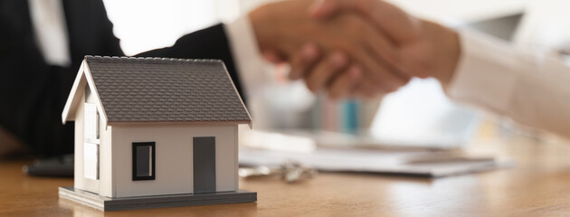 Fototapeta premium Close up view hands of agent and client shaking hands after signed contract buy new apartment.