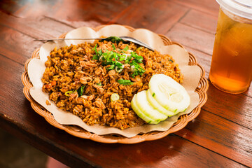 Freshly cooked fried rice on a woven bamboo plate with oil paper lining
