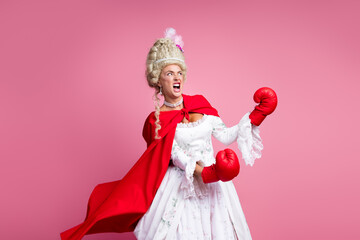 Graceful noblewoman in baroque attire with modern boxing gloves blending historical fashion and contemporary concepts on a pink background