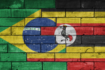 colourful painted big national flag of uganda and flag of brazil on a massive old brick wall background. concept